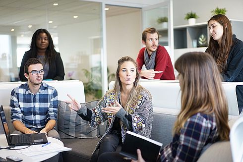 Junge Leute arbeiten in eine Sitzung als Team zusammen